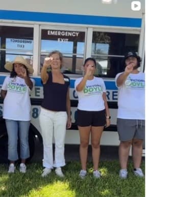 Victoria Doyle and supporters in front of a campaign bus